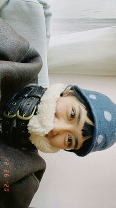 a young boy wearing a hat and jacket