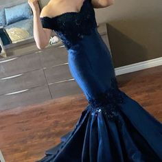 a woman in a blue dress taking a selfie