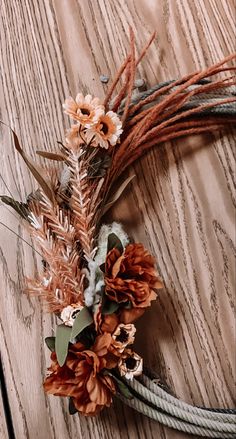 an arrangement of dried flowers on a wooden surface