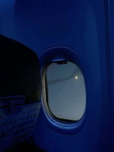 an airplane's window is seen from inside the cabin area, with light shining on it