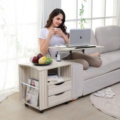 a woman sitting on a couch using a laptop computer