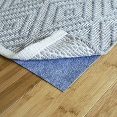 a close up of a wooden floor with a rug on top of it and an area rug in the middle