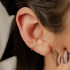 This ear cuff is made from 18 karat gold-plated sterling silver and consists of a single band with squared edges, half covered with tiny white zircon stones embellishing the outer surface. It has a small gap in the band where it fits onto the ear, and two metallic balls on either side of the gap to hold it securely in place. Simple yet sophisticated, this is a versatile piece that will add the perfect amount of extra sparkle to an outfit.  DETAILS: Diameter: Outer diameter: 1.4 cm Weight: 1.0 g Material: 18 k gold plated, 925 Sterling Silver 🏷️ This product is made of sterling silver -- easily recognizable by its '925' stamp of authenticity. It is also hypoallergenic, making it suitable for people with sensitive or irritable skin. We recommend avoiding perfume, deodorant or other chemical 14k Gold Pierced Ear Cuff Fine Jewelry, Gold Plated Huggie Ear Cuff Single Earring, Single Rose Gold Ear Climber In 14k Gold, Rose Gold Single Ear Climber In 14k Gold, Rose Gold 14k Gold Ear Cuff, Gold Plated Single Ear Cuff Fine Jewelry, Rose Gold 14k Gold Ear Cuff For Pierced Ears, 14k Rose Gold Ear Cuff, Single 14k White Gold Ear Cuff