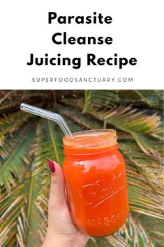 a hand holding a mason jar filled with orange juice and the words paradise cleanse juicing recipe