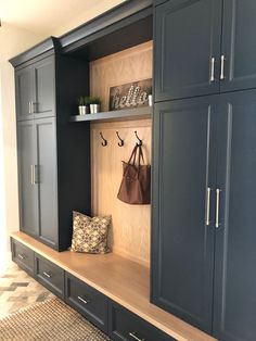 an entryway with blue cabinets and hanging bags