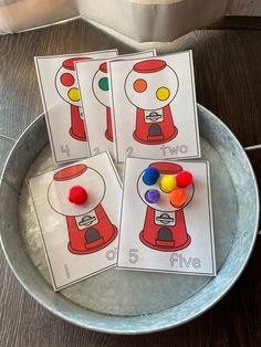 three cards with gummy bears on them in a metal bowl next to a lamp