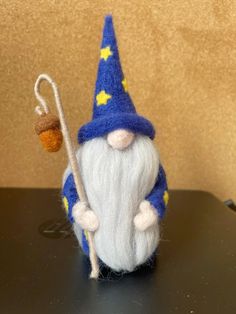 a needle - felted gnome with a small acorn on it's back