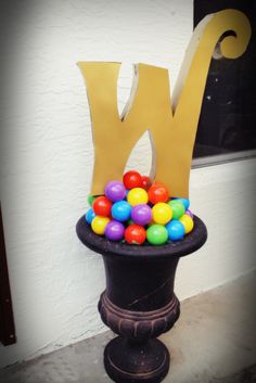 the letter n is made out of candy balls and sits on top of a pedestal