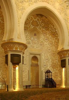 the inside of a building with columns and arches on it's walls, decorated with intricate designs