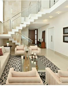 a living room filled with furniture next to a stair case