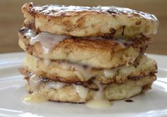 a stack of pancakes sitting on top of a white plate covered in frosted toppings