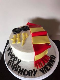 a birthday cake decorated with an image of a man's hat, scarf and glasses