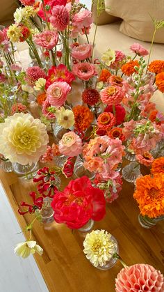 a wooden table topped with vases filled with flowers