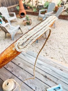 a piece of rope that is on top of a wooden table with chairs in the background