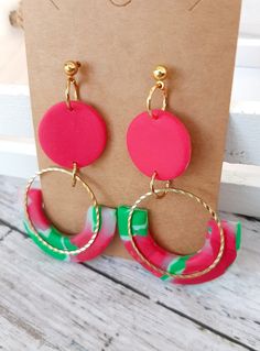 These fun clay watermelon inspired earrings are sure to make an impression at any summer picnic or party.  How fun to make a statement with the refreshing colors of watermelon hanging from your ears! These bright earrings in red and green shades are perfect for a hot summer day. The gold accent is a classic touch to this pair of dangle earrings. Meraki Made Earrings are always made with care and attention to detail. *Each pair of earrings is handmade so slight variations may occur. Want to see more Summer Styles? Click here! https://www.etsy.com/your/shops/MerakiMadeClay/tools/listings/section:42972676,stats:true Check out more Meraki Made styles here! https://www.etsy.com/shop/MerakiMadeClay Playful Green Polymer Clay Jewelry, Fun Green Polymer Clay Jewelry, Playful Handmade Red Earrings, Fun Pink Polymer Clay Earrings, Clay Watermelon, Bright Earrings, Earrings For Summer, Clay Dangle Earrings, Green Shades