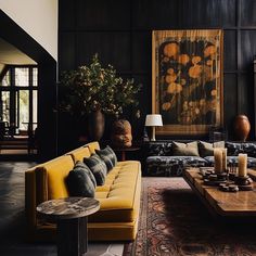 a living room filled with lots of furniture next to a painting on the wall above a coffee table