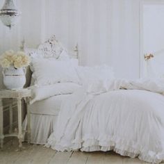 a bed with white sheets and pillows in a room