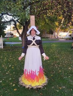 a woman dressed in costume standing on grass