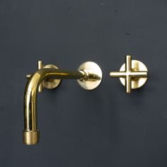 two gold cross handles on a black wall