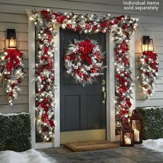 a christmas wreath on the front door of a house decorated with red and white decorations