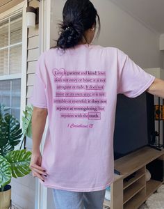 a woman standing in front of a tv wearing a pink t - shirt with the words love is patient and kind of love