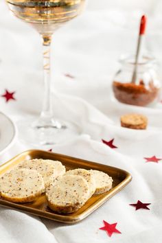 two pieces of bread on a plate next to a glass of wine and some condiments