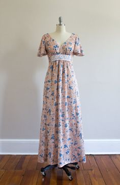 Vintage Maxi dress from the 1970's. This dress features a lovely floral print, feminine flutter sleeves, v-neck in front, open scoop back that ties at the top, and an empire waist with crochet detailing under bust. Metal zipper closure at back.MeasurementsBust- 34"Waist- 28"Hips- up to 36"Length- 54"Shoulders- 16"*Condition* Excellent vintage condition. Cleaned and ready to wear!**I now accept returns on most items with certain conditions, so please read shop policies before purchasing. Thank yo Retro V-neck Lined Maxi Dress, Spring Vintage V-neck Maxi Dress, Retro Flowy V-neck Maxi Dress, Vintage V-neck Maxi Dress For Spring, Flowy V-neck Retro Maxi Dress, Fitted Bohemian Maxi Dress With Flutter Sleeves, Retro V-neck Maxi Dress For Spring, Vintage V-neck Maxi Dress For Garden Party, Vintage Flowy Printed Maxi Dress