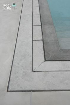 an empty swimming pool surrounded by concrete blocks and cement edgings, with no people in it