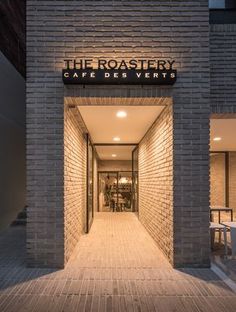 an entrance to a restaurant with brick walls and lights on the outside, along with wooden flooring