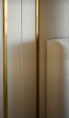 a bathroom with a white toilet and gold trim