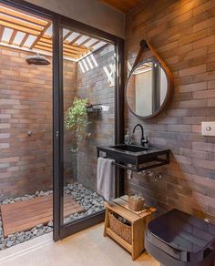 a bathroom with a sink, mirror and shower stall in the corner next to a wooden bench