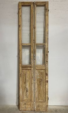 an old wooden double door with glass on the front and side doors, in a white room