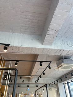 an empty room with exposed ceilings and lights hanging from it's ceiling above the counter