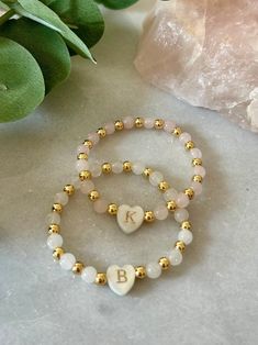 - The cutest little girl initial bracelet. This delicate and dainty initial beaded bracelet has a freshwater shell heart initial with 18k gold filled and gemstone beads. A perfect and sweet personalized new baby gift or toddler bracelet. Beaded on high quality stretch cord and secured. - 4mm 18k gold filled beads   5mm gemstone beads ( white jade, rose quartz) ‼️Young children MUST be supervised at all times while wearing jewelry. Contains small parts that could be a potential choking hazard. Jewelry should always be removed during sleep. Never leave young children unattended with our products. Supervision is required. It is at the customers discretion for the use of our products.  - Each purchase is sent in a velvet drawstring jewelry bag, making the perfect 1st birthday personalized gift Personalized Pink Dainty Beaded Bracelets, Dainty Beaded Bracelets For Birthday, Dainty Letter Beads Beaded Bracelets For Birthday, Dainty Beaded Bracelets With Letter Beads For Birthday, Dainty Letter Beads Bracelet For Birthday, Dainty Adjustable Beaded Bracelets, Delicate White Personalized Bracelets, Delicate Personalized White Bracelets, Personalized Dainty Charm Bracelet With Round Beads