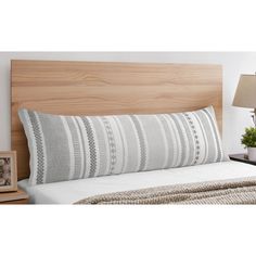 a bed with a wooden headboard and pillows