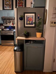 a kitchen area with a refrigerator, trash can and other items on the counter top