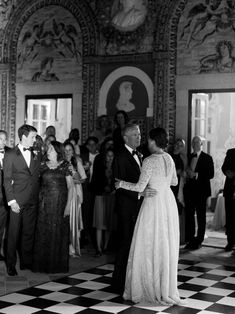 a man and woman dance together in front of an audience at a formal event, dressed in black and white