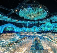 a banquet hall with blue lights and chandeliers