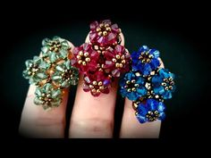 three different colored rings sitting on top of each other in their hands with gold and blue beads