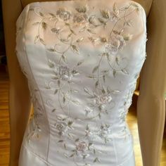 a white wedding dress with flowers on it