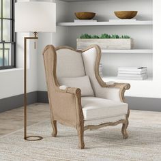 a living room with a chair, lamp and bookshelf