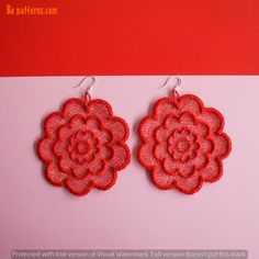 pair of red flower earrings on pink background