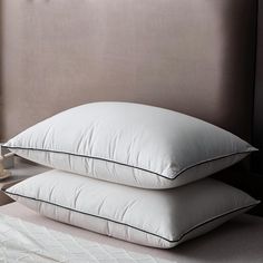 two pillows sitting next to each other on a bed