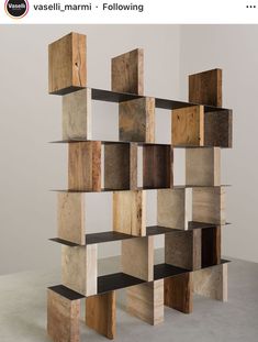 a book shelf made out of wood blocks on top of cement floor next to wall