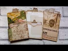 three pieces of paper with clipboards attached to them on a white brick wall background