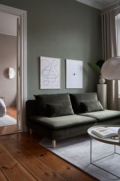 a living room filled with furniture next to a window and a painting on the wall