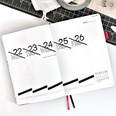 an open planner book sitting on top of a table next to a pair of scissors