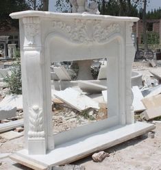 a white marble fireplace surround surrounded by rubble