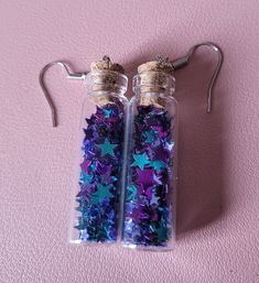 These cute earrings feature blue and purple star glitter in little bottles, with silver ear hooks. Blue Star Charm Earrings For Party, Star Shaped Glitter Earrings For Party, Purple Glitter Earrings For Gift, Galaxy Accessories, Trixie Lulamoon, Purple Stars, Purple Accessories, Purple Star, Bottle Earrings