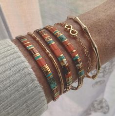 a woman's arm with several bracelets on it